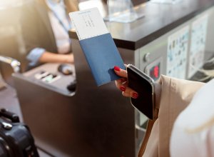 Lady holding passport and tickets and going to go through passport control